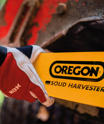 Main avec des gants de travail rouges KOX tenant un guide de rcolte jaune portant le logo OREGON et l’inscription Solid Harvester.